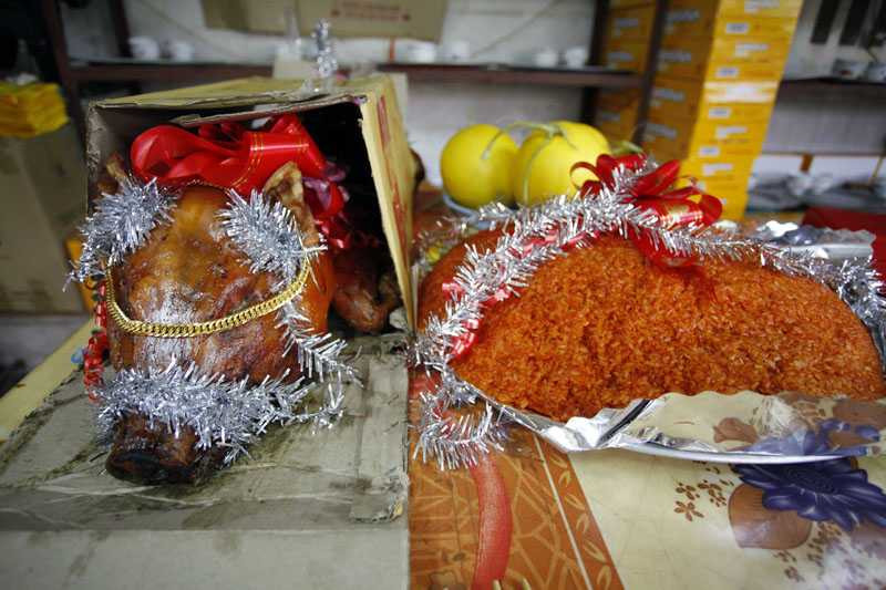 Lợn quay và xôi gấc cũng được chuẩn bị để làm lễ.