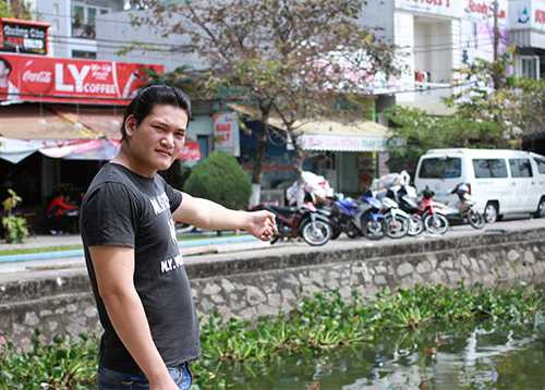 Anh Vũ chỉ địa điểm vớt được nạn nhân Giang dưới hồ Hàm Nghi. Ảnh: Nguyễn Đông.