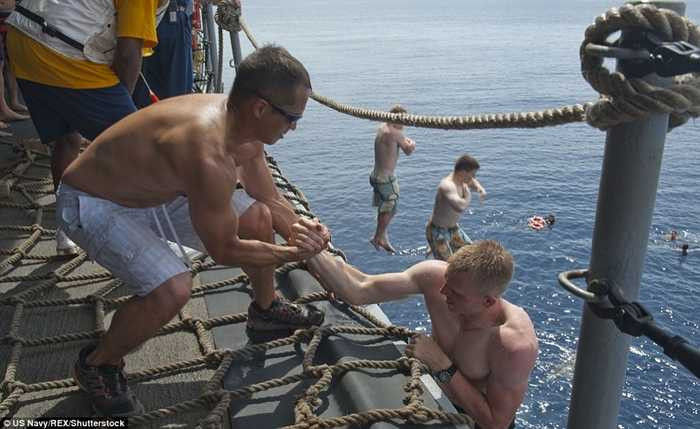 Các thủy thủ kéo nhau lên tàu sau khi bơi lội thỏa thích