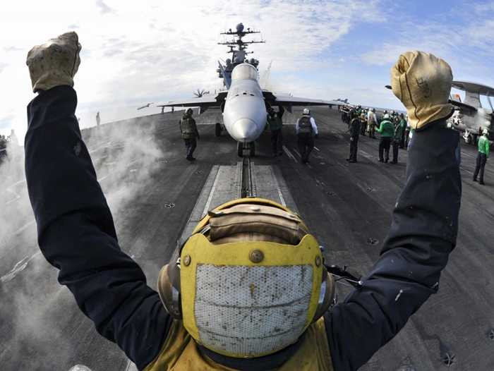 Hoa tiêu chỉ dẫn cho F/A-18C Hornet di chuyển trên sàn của tàu sân bay USS Harry S. Truman