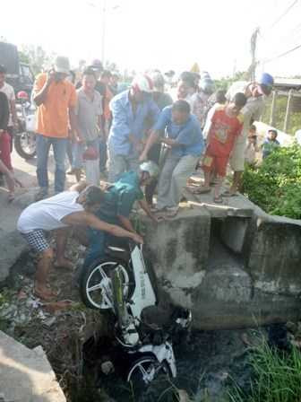 Chiếc <a href='https://vtcnews.vn/oto-xe-may.31.0.html' >xe mô tô</a> được đưa từ dưới cống nhà kho lên bờ.