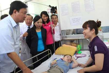 Bí thư Thành ủy TP HCM Đinh La Thăng cùng Bộ trưởng Bộ Y tế Nguyễn Thị Kim Tiến thăm hỏi người nhà của một bệnh nhi đang điều trị ở bệnh viện Bình Tân. Ảnh: Phan Tư