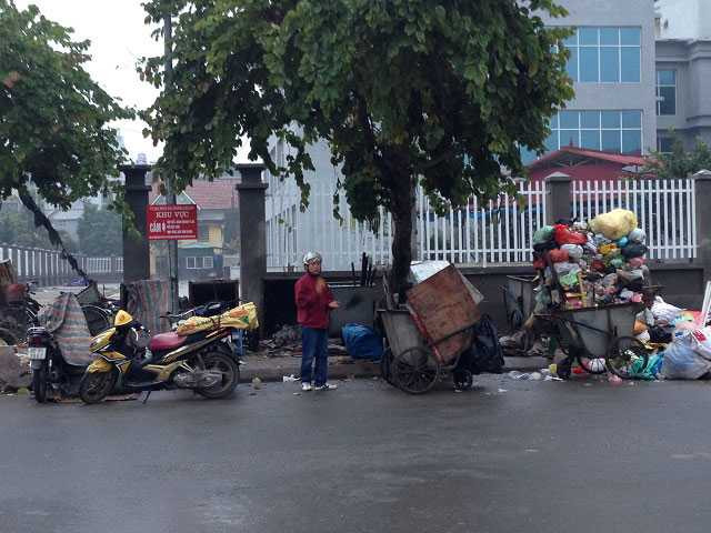 Biển báo ghi rõ “cấm tập kết rác thải” song người dân cũng như các công nhân quét rác vẫn đem rác ra đổ. Điều đáng nói là mọi người coi đây là điều hiển nhiên và làm một cách công khai. (Ảnh chụp tại phố Trung Kính, Cầu Giấy tháng 1/2016)