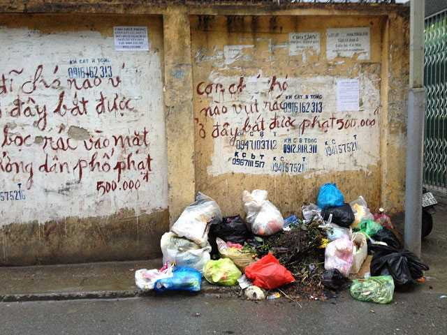 Những dòng chữ răn đe cùng hình phạt 500.000 đồng cũng không làm người dân thôi đổ rác. (Ảnh chụp tại phố Yên Hòa, Cầu Giấy tháng 1/2016)