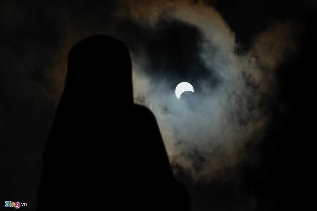 Nhật thực qua tượng Đức Mẹ Hòa Bình trước Quảng trường Công xã Paris .