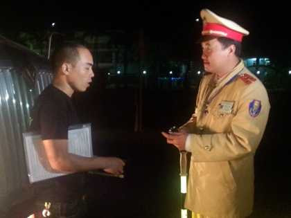 Đại úy Dương Công Huy nhắc nhở tài xế xe BKS 15C-157.01 không được dừng đỗ ở đoạn đường nguy hiểm. Ảnh Đ.A