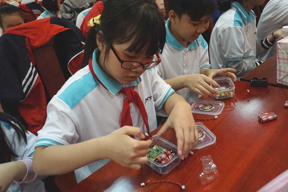 Các em nhỏ chăm chú lắp ráp máy ghi âm theo hướng dẫn