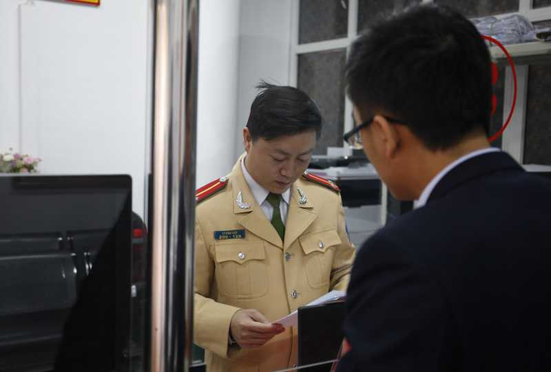 Anh Phạm Duy Dương (áo đen) đến cơ quan công an chứng minh chiếc xe vi phạm theo thông báo không phải là xe nhà mình.