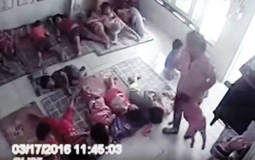 Nữ giáo viên xách tay bé gái. Ảnh chắt từ camera