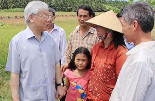 Tổng bí thư thăm hỏi, chia sẻ khó khăn với người dân vùng bị thiên tai. Ảnh: Cửu Long