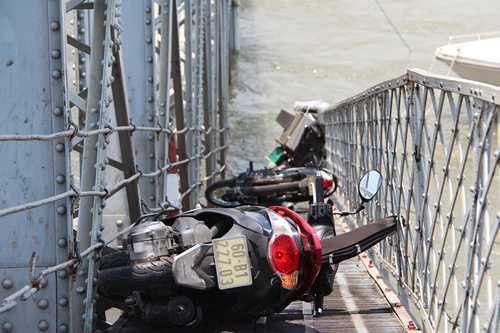 Xe máy của những người bị rơi xuống sông còn mắc lại trên cầu (Ảnh: Hoàng Trường/VNE)