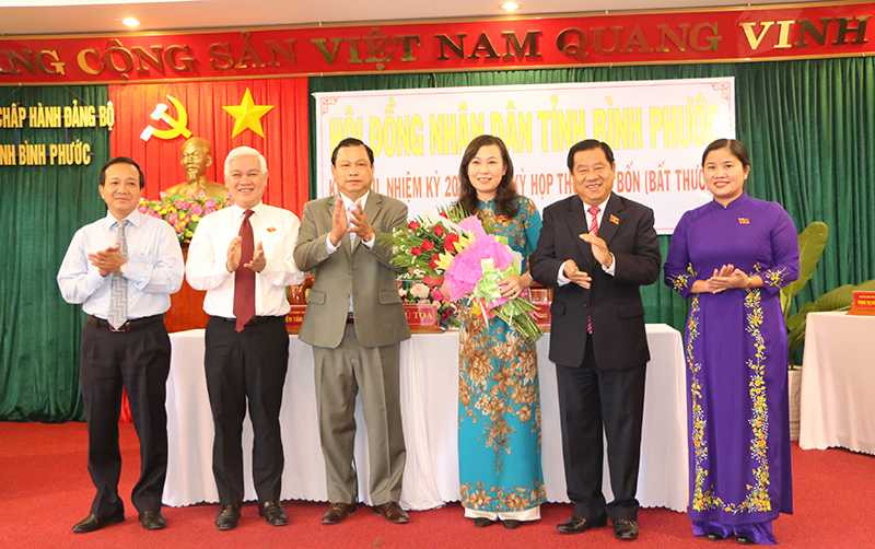 Bà Huỳnh Thị Hằng (thứ ba từ phải sang) nhận hoa chúc mừng của lãnh đạo Tỉnh ủy, HĐND, UBND, Uỷ ban MTTQ Việt Nam tỉnh.