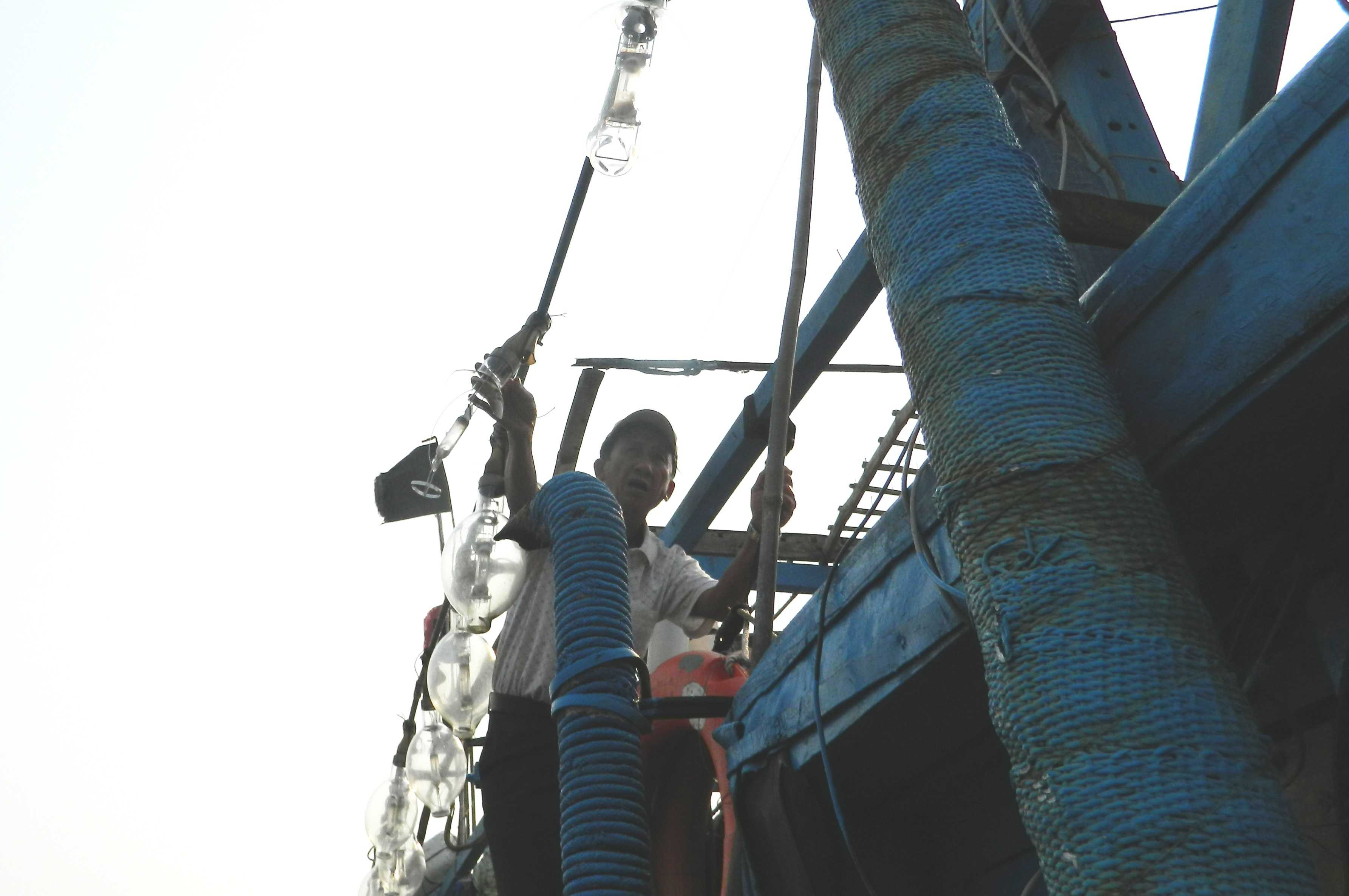 Ngư dân sinh đã thay lại bóng đèn chong cá bị Trung Quốc bắn bể.