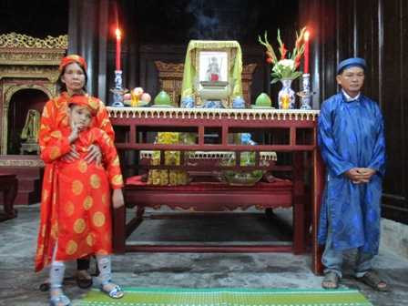 gia đình ông Tài trước ngai thờ vua Thành Thái.