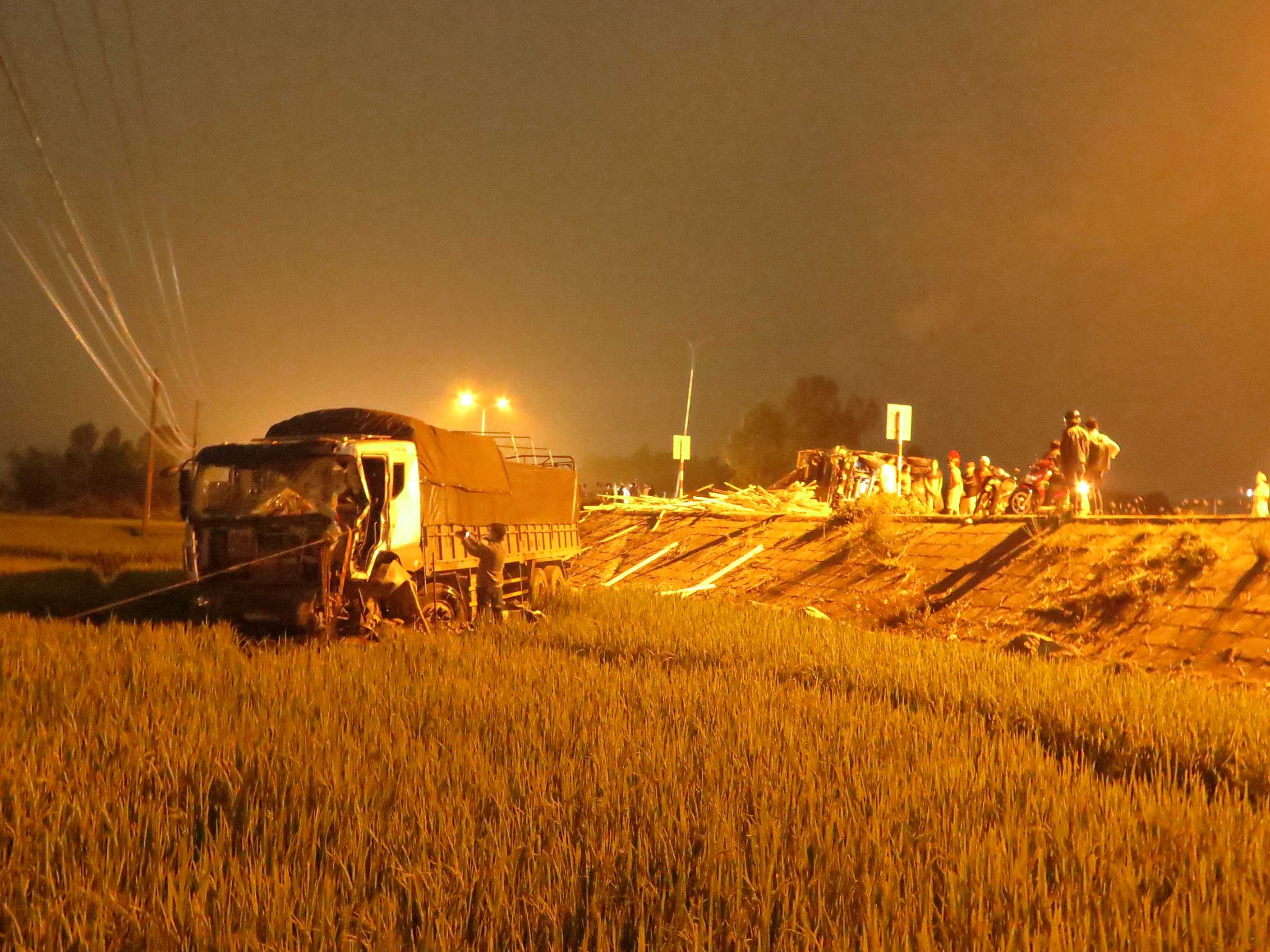 Chiếc xe tải lao xuống ruộng, ca bin bẹp dúm khiến tài xế bị kẹt bên trong.