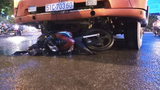 Uống rượu bia rồi chạy xe chở vợ, bị xe đầu kéo cuốn vào gầm - Ảnh 1.