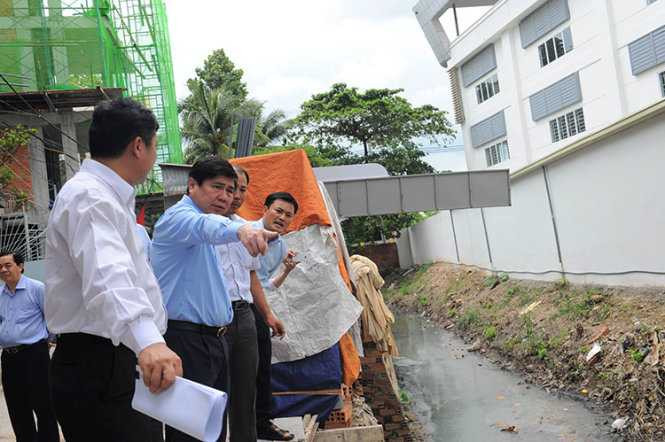 Chủ tich UBND.TP.HCM Nguyễn Thành Phong kiểm tra mương A41 (Q. Tân Bình) giải quyết thoát nước khu vực sân bay Tân Sơn Nhất bị lấn chiếm, rác rến... - Ảnh: TỰ TRUNG