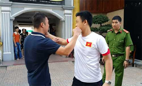 Chu Đức Gu Lít (áo phông xanh đen, bên trái) cùng cảnh sát đóng thế mô phỏng lại cảnh xô xát. Ảnh: Hải Bình.