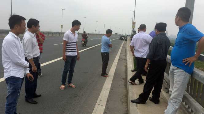 PV Quang Thế (ngoài cùng bìa trái) và chiến sĩ cảnh sát Ngô Quang Hưng (thứ 3 từ trái sang) cùng CQĐT đến cầu Nhật Tân xác định vị trí xảy ra việc PV Quang Thế bị hành hung - Ảnh: THÂN HOÀNG