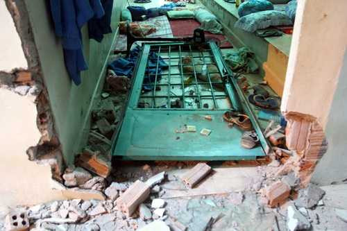 Một cánh cửa bị đập vỡ, xô đạp vào trong phòng.