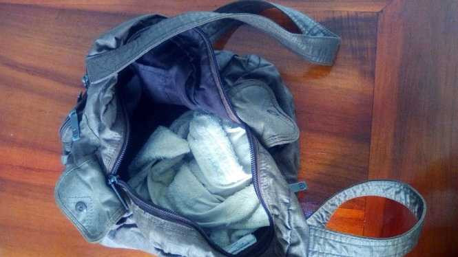 Chiếc túi xách đựng bé gái trong chòi vườn cao su - ảnh: B.L