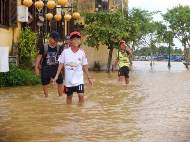 Trẻ em Hội An lội nước trên đường Bạch Đằng - Ảnh: THANH BA