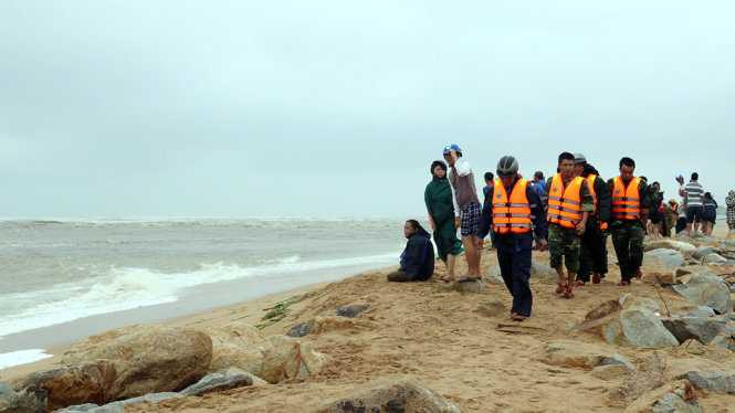 Người nhà bốn ngư dân ở TP Tuy Hòa và các lực lượng chức năng bất lực vì không cứu được các nạn nhân do sóng biển quá lớn - Ảnh: NGÔ XUÂN