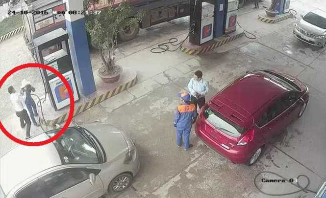 Hình ảnh ông Đức dùng cò bơm xăng đánh chị Ng. được camera cây xăng ghi lại - Ảnh: D.HÒA chụp màn hình