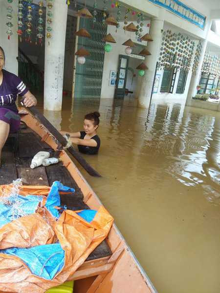 Cô giáo trường mầm non Phương Mỹ dầm mình trong nước lũ để thu dọn, vận chuyển đồ đạc lên cao (ảnh: Trường Mầm non Phương Mỹ).