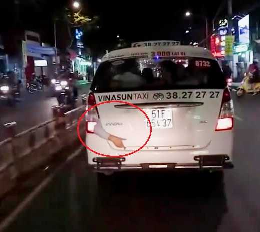 Cánh tay lòi khỏi đuôi taxi khiến nhiều người không khỏi rùng mình (ảnh cắt từ clip)