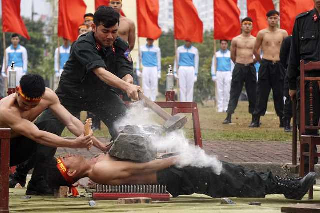 Sức chịu đựng phi thường của một chiến sỹ khi thực hiện bài tập nằm trên đinh, đặt đá lên ngực, sau đó dùng búa tạ đập vỡ phiến đá.