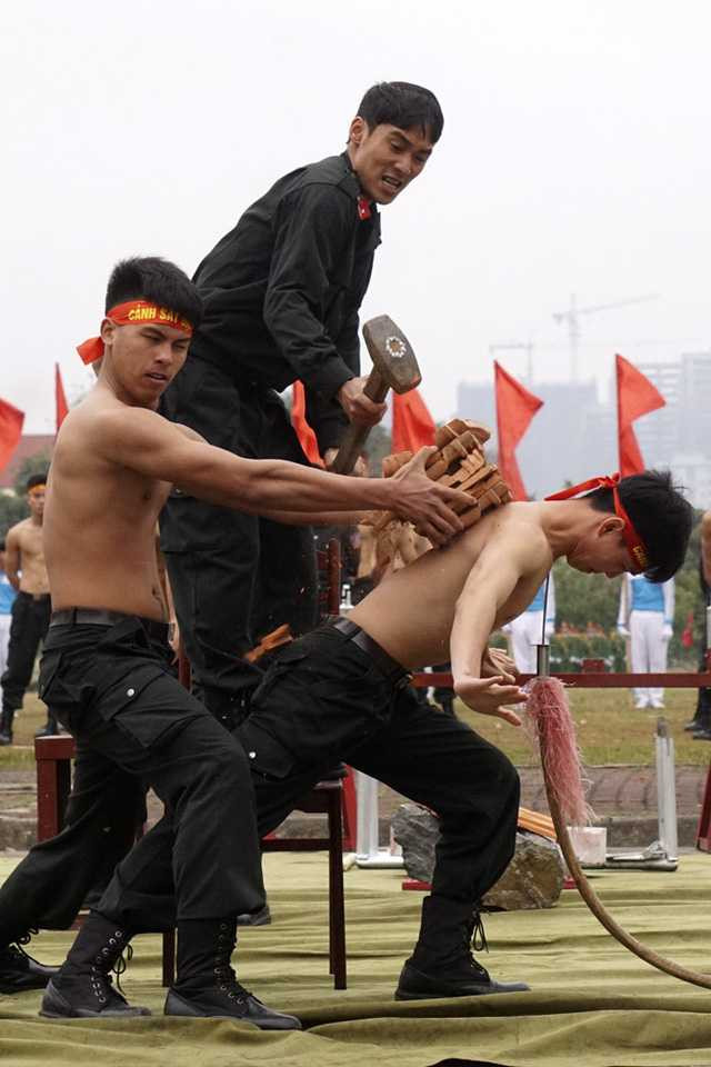 Khả năng khí công phi thường của một chiến sỹ trong bài trình diễn đè lưỡi giáo nhọn vào cổ đồng thời dùng búa tạ đập vỡ gạch đặt trên lưng.