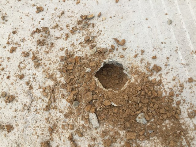 Chọc nhẹ thủng lớp bê tông dầy 2 cm thì lộ ra đất và cát phía dưới.