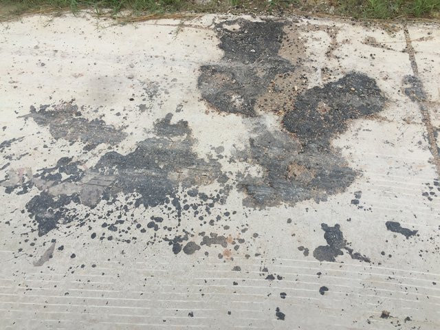 Mặt đường bê tông chưa nghiệm thu đã bị vá nhựa đường nham nhở.
