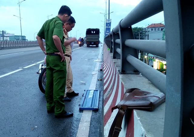 Công an kiểm tra những thứ sót lại ở hiện trường nghi là của chiếc xe xảy ra va chạm với nạn nhân