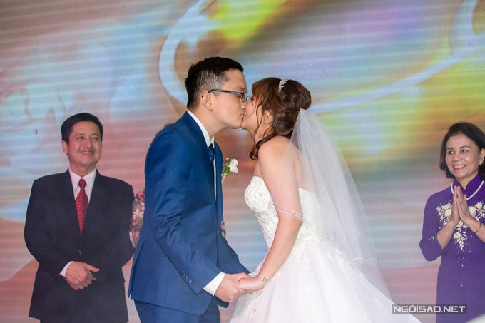Cặp đôi trao nhau nụ hôn ngọt ngào trước sự chứng kiến của bố mẹ và bạn bè. 
