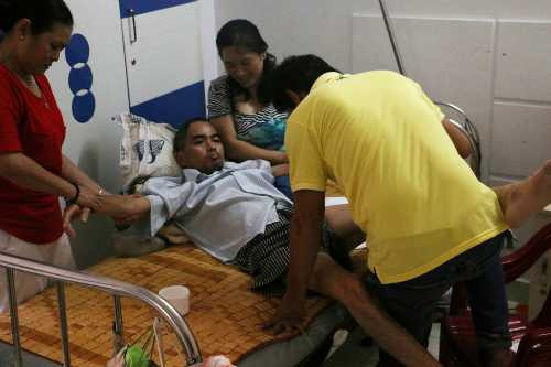 Nguyễn Hoàng (áo trắng) được tập vật lý trị liệu tại nhà.