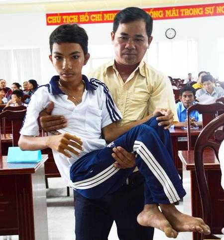 Thầy Phạm Văn Quán bế em Nhành lên nhận học bổng.