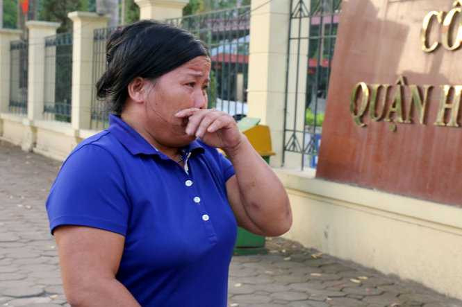 Bà Lan, vợ ông Thạch không kiềm chế được cảm xúc khi đứng chờ chồng trước cổng trụ sở công an quận Hoàng Mai - Ảnh: HOÀI NAM