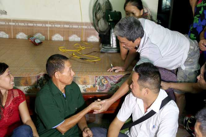 Những người đồng đội năm xưa ở mặt trận Vị Xuyên, Hà Giang nắm tay động viên ông Thạch - Ảnh: HOÀI NAM