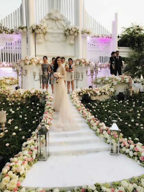 Lễ cưới được tổ chức ngoài trời. Không gian trang trí ấn tượng với hai tông màu trắng - hồng chủ đạo.