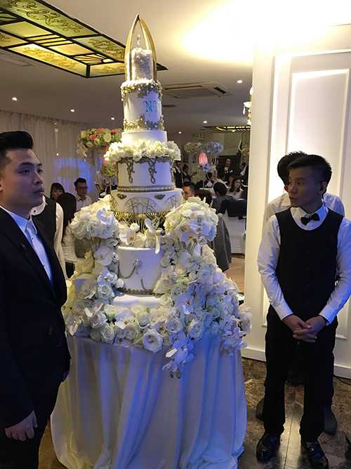 Bánh cưới 7 tầng cao gần 2m tông trắng đính ngập hoa tươi.