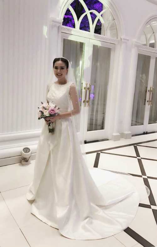 Trong đám cưới, MC 9X chọn mặc hai bộ váy: một thiết kế của NTK Phương Linh đính 10.000 viên pha lê và một bộ váy của thương hiệu Rosa Clara có giá 10.000 USD khi làm lễ.