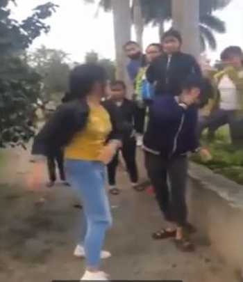 Nữ sinh mặc quần bò xanh liên tục tát và đá vào bụng đối phương. Ảnh: Cắt từ video.