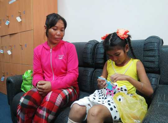 Thắm chăm chú vào những món đồ chơi mẹ mới mua để mừng bé được xuất viện. Bé cho biết bây giờ bé mong nhất là được về gặp anh trai