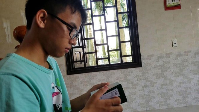 Huy kiểm tra lại giấy tờ hồ sơ trước khi lên xe ra Hà Nội phỏng vấn lần ba - Ảnh: QUỐC NAM