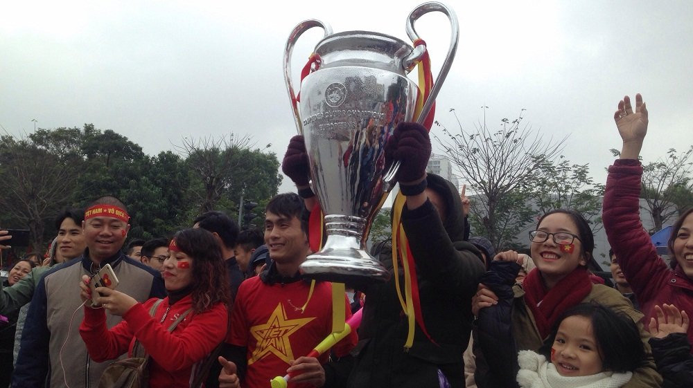 Clip: CĐV vác cúp Bạc 'khủng' ra đường đón tuyển U23 về nước