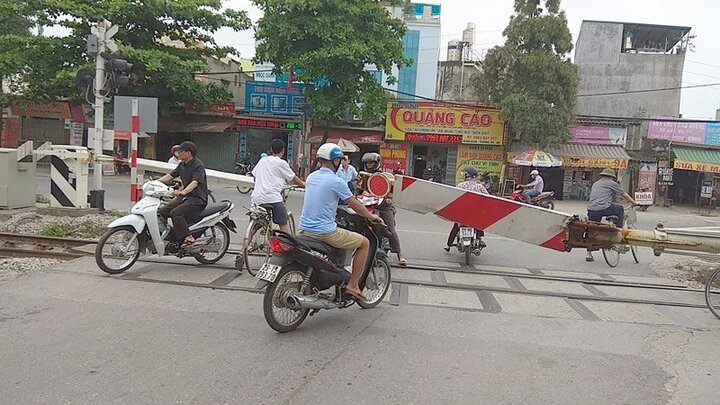 Tàu đang ầm ầm lao tới, dân coi thường mạng sống vẫn cố lách barie băng qua đường ray