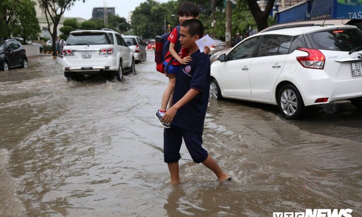 Học sinh được cõng, bồng bế đi học về qua khu nhà giàu ở TP.HCM ngập nặng