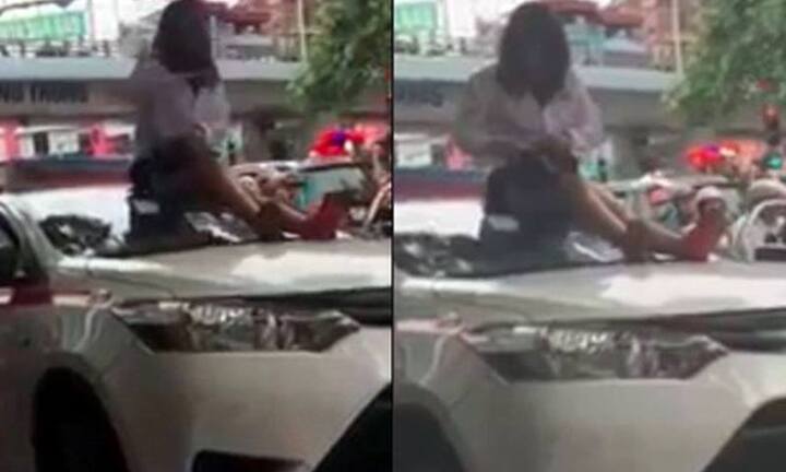 Bị CSGT dừng xe, nữ tài xế taxi vượt đèn đỏ trèo lên nóc xe ăn vạ